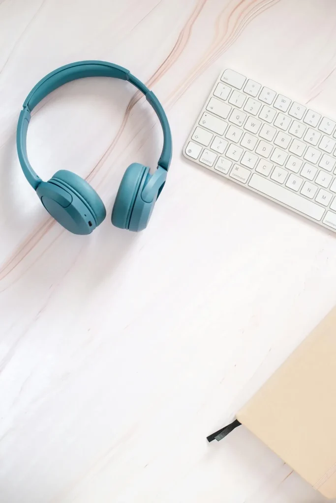 Teal over-ear headphones on a desk flat lay — how noise cancelling ANC technology works