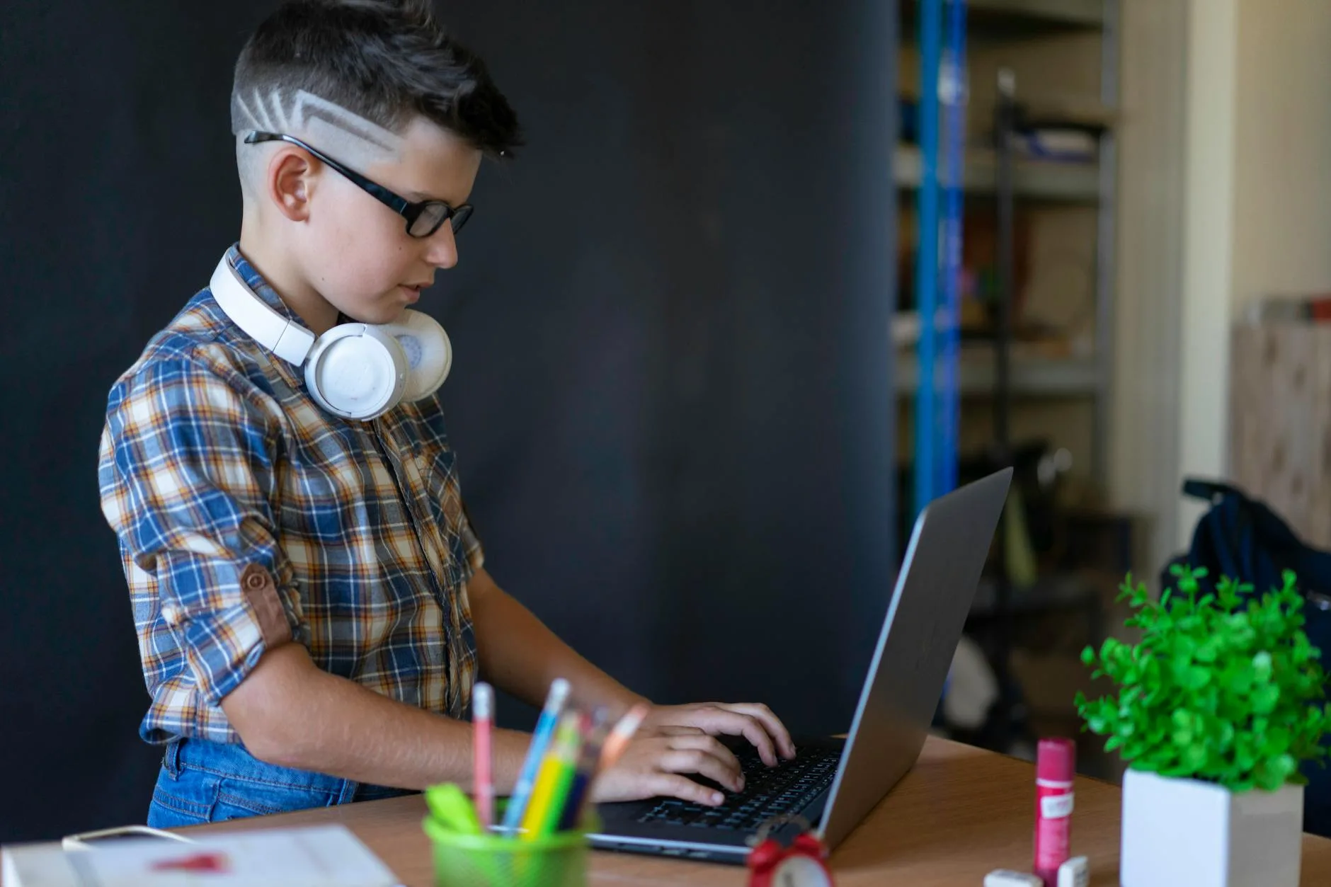Boy wearing headphones while studying at school