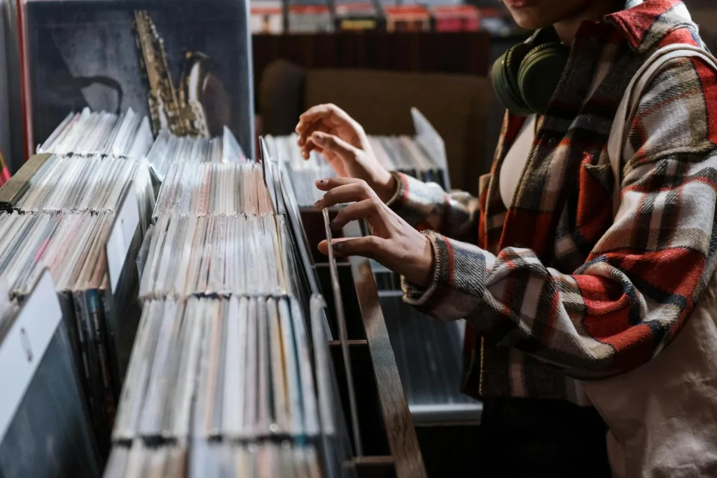 Person browsing through vinyl records in a record shop