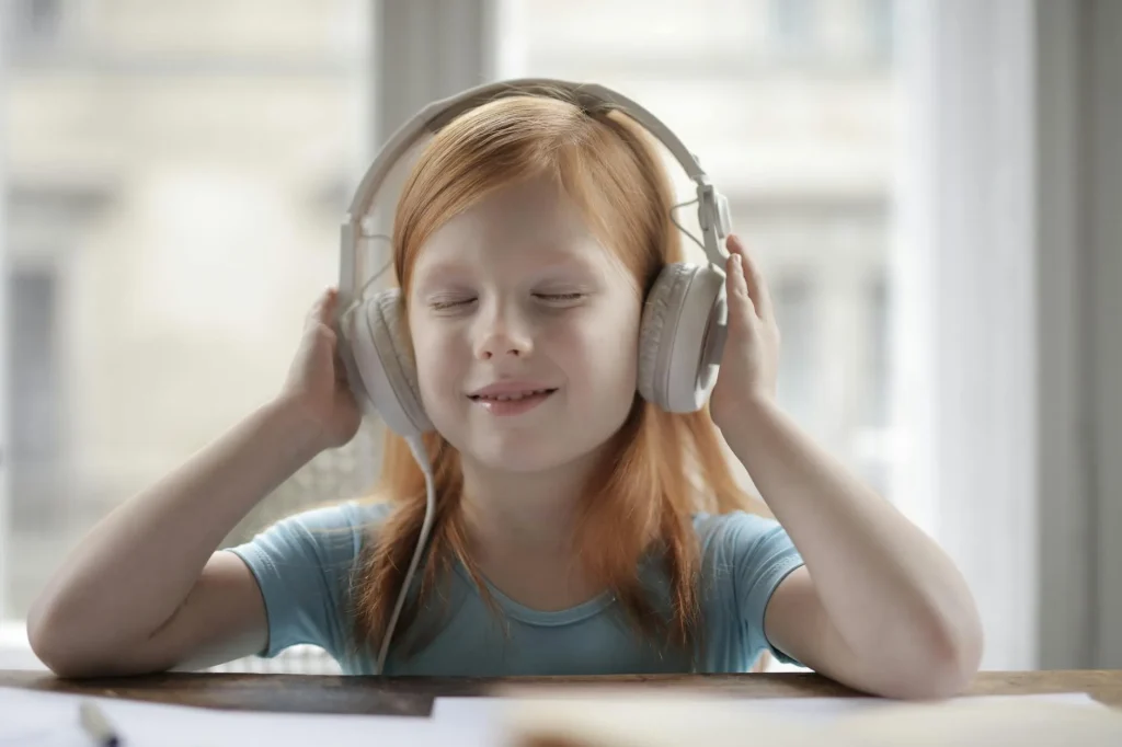 Happy child wearing headphones while using a tablet