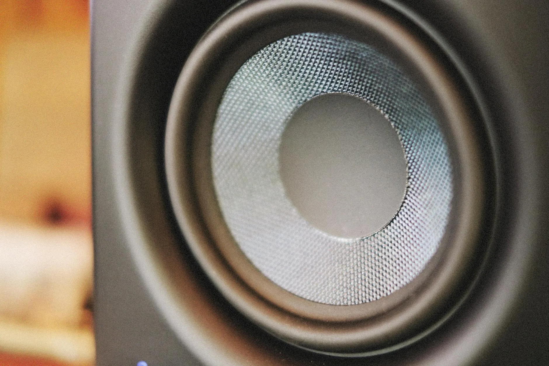 Close-up of a subwoofer speaker driver in a home audio setup