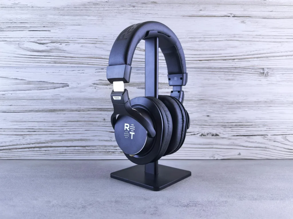 Over-ear headphones resting on a studio desk next to audio equipment