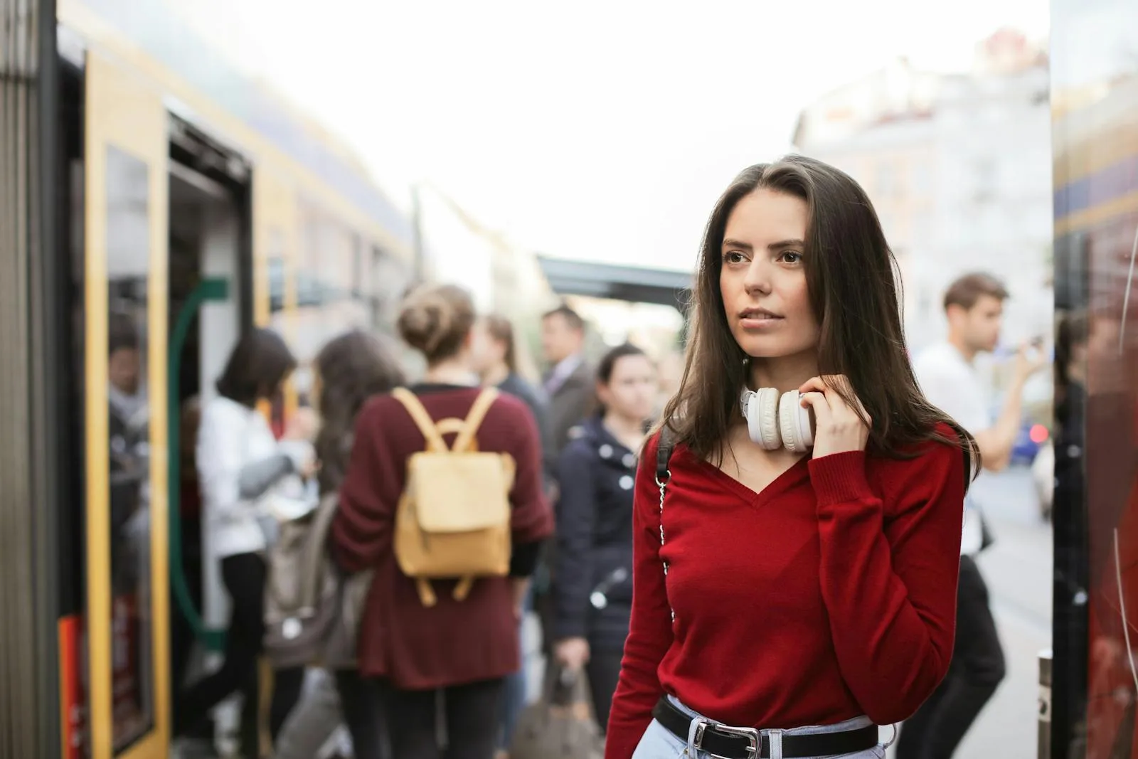 Young woman wearing over-ear headphones while commuting