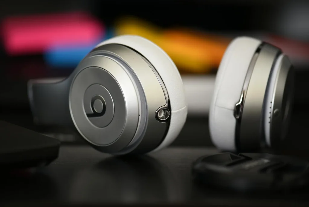 Over-ear headphones on a desk beside a turntable and amplifier
