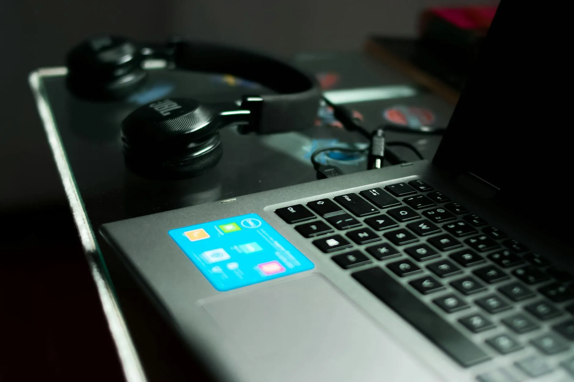 Over-ear headphones resting on a laptop desk listening setup
