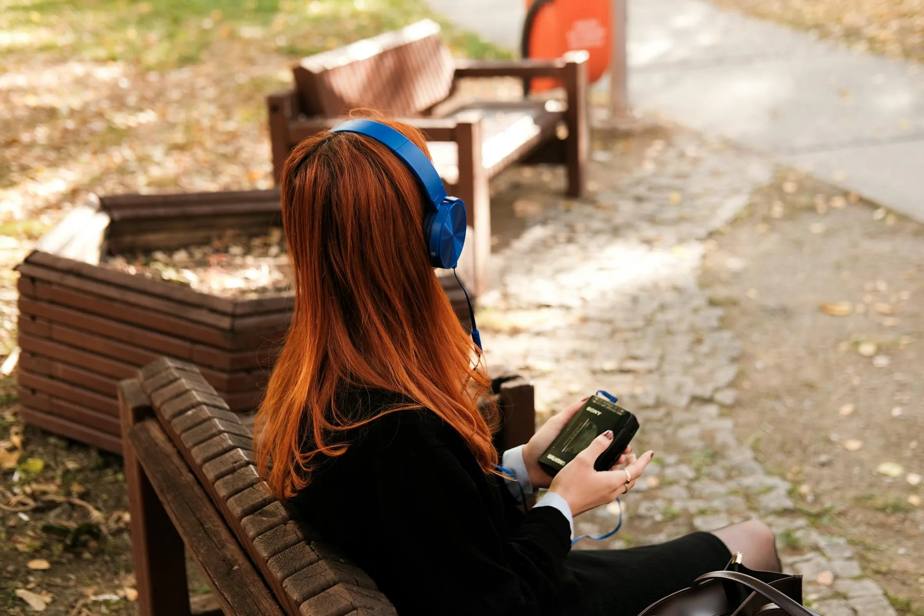 Person wearing headphones while listening to music on a smartphone