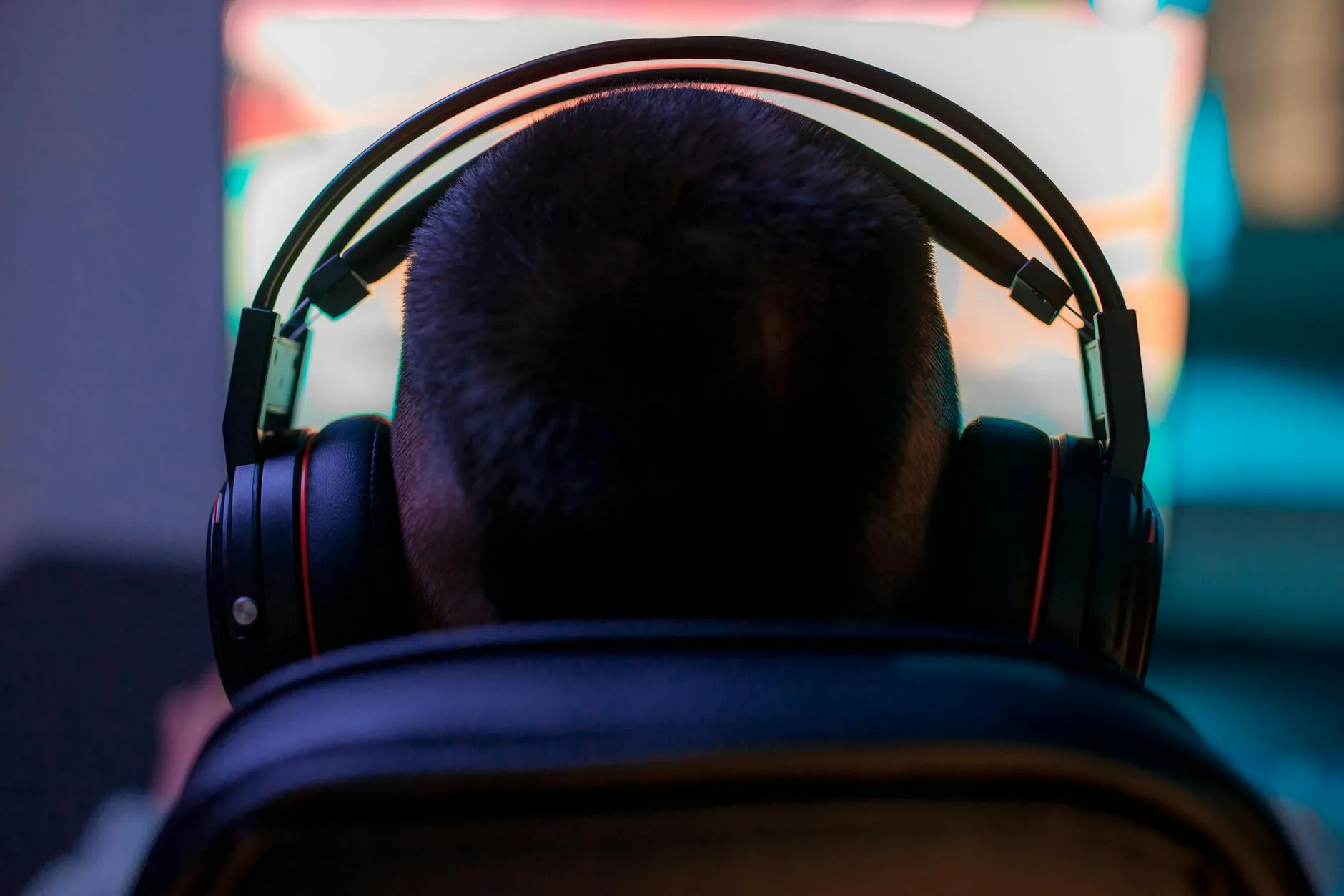 Person wearing headphones while gaming on a computer