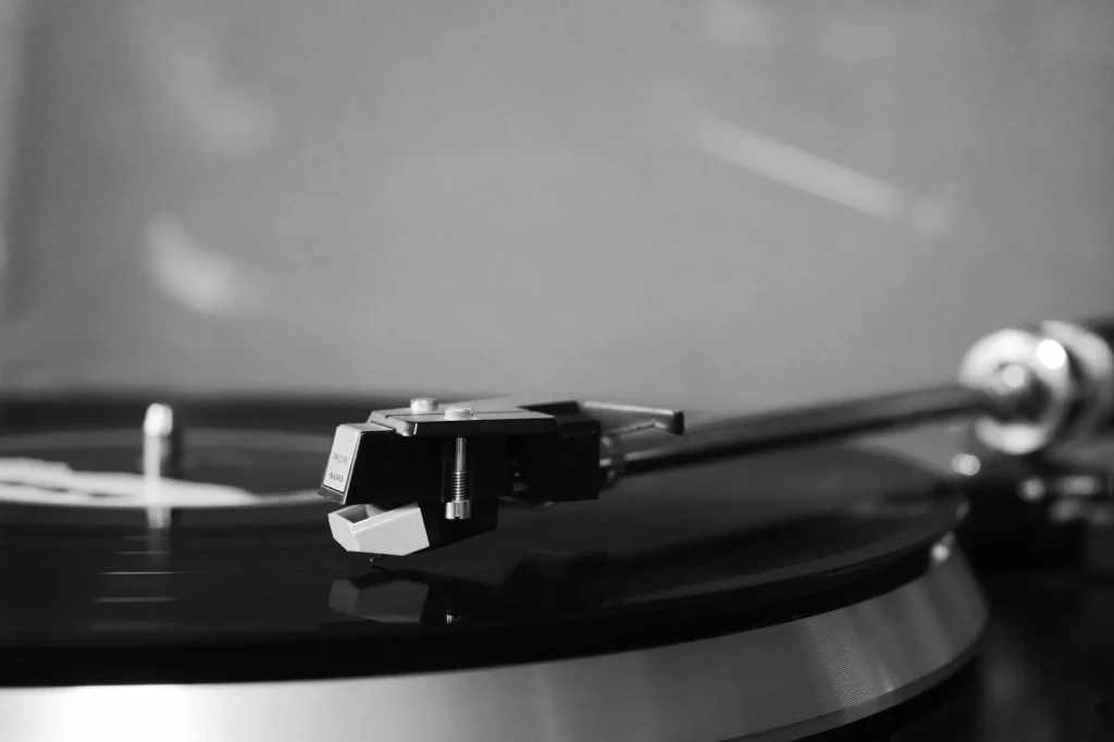 Close-up of a turntable cartridge and stylus on a vinyl record