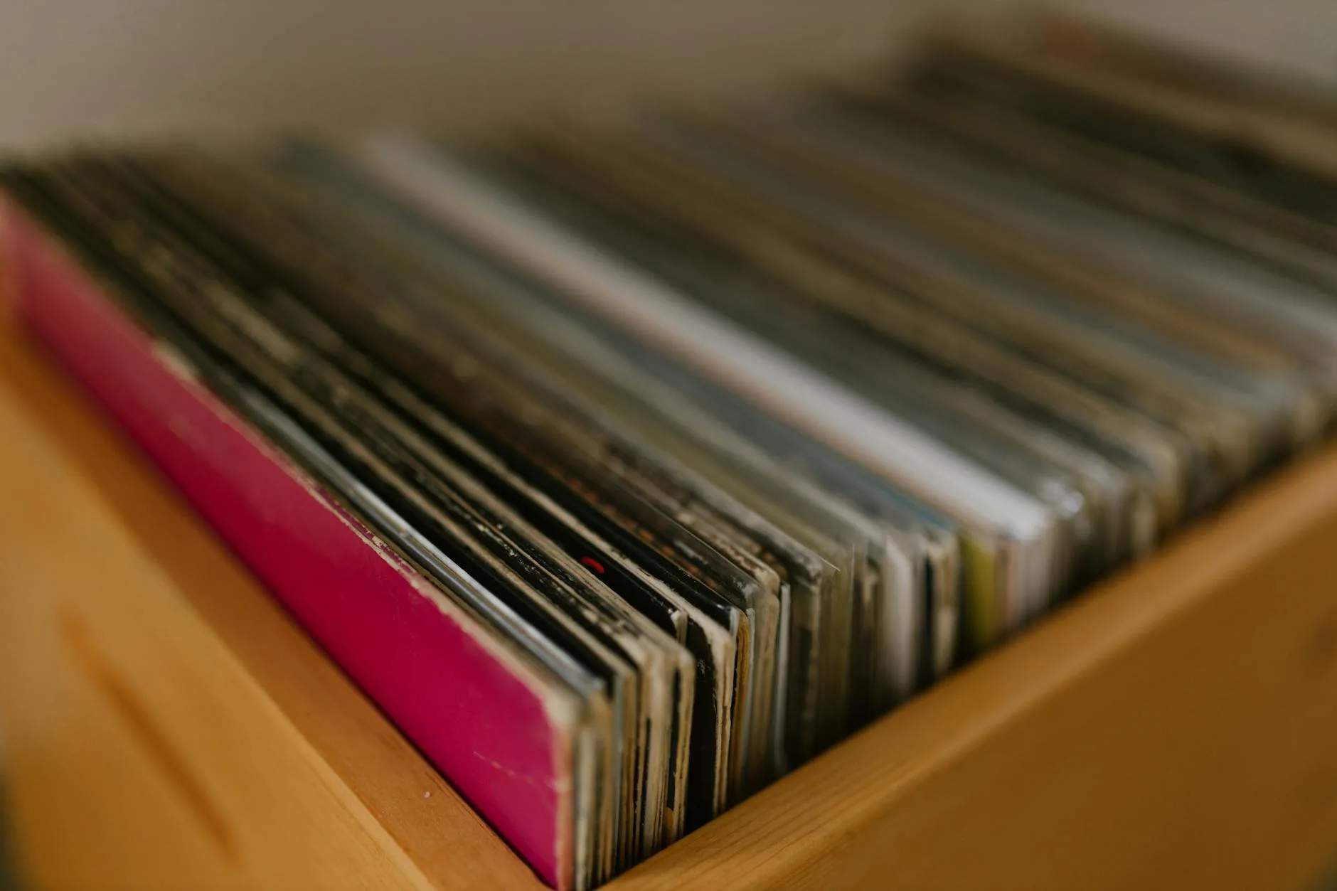 Collection of vinyl records stored on a shelf beside a turntable
