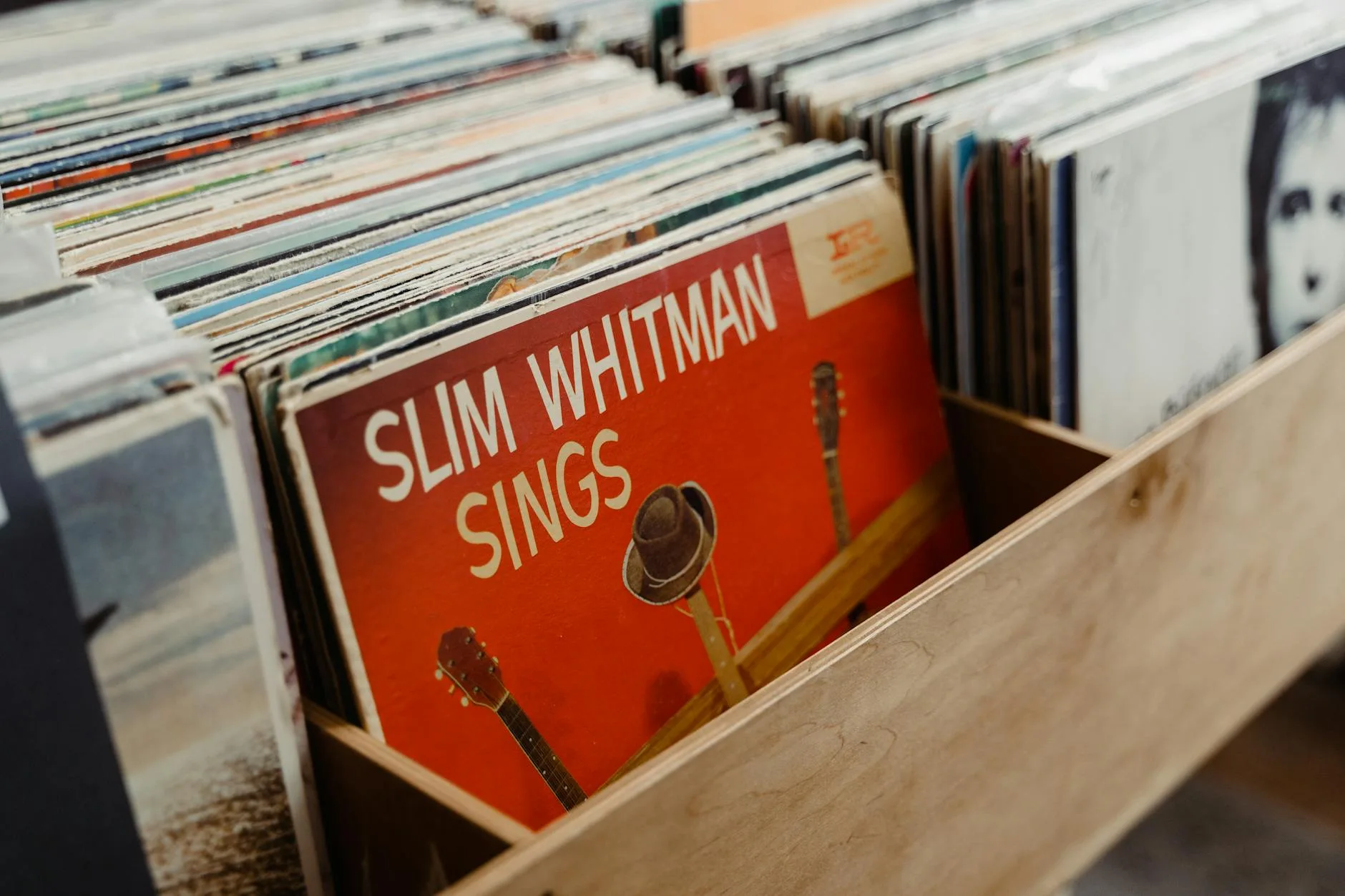 Browsing vinyl records in a wooden storage crate