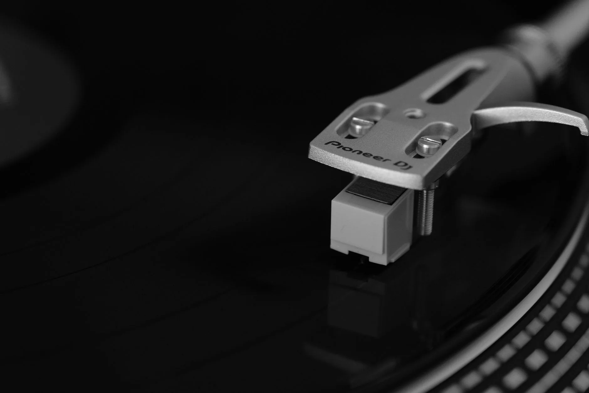 Turntable tonearm and cartridge close up on a vinyl record